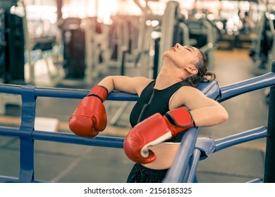 Tired woman athlete resting after boxing leaning in fitness gym - Powered by Shutterstock