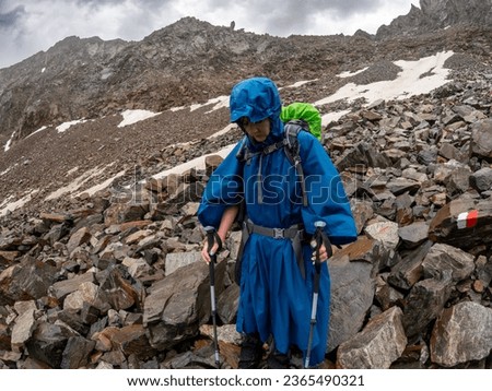 Tired woman decending the mountain in rainy weather, Falbesoner Valley, Stubai Alps, Austria
