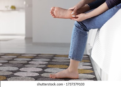 Tired Woman Doing Self Foot Massage For Pain Relief After Fatigue, Long Walking, Working, Standing, Flat Feet Or Injury, Sitting Indoors. Suffering From Hurt Of Arch, Ball, Heel Or Toe Treatment