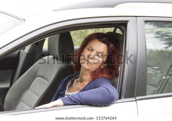 Tired woman driver sleeps\
in the car