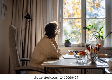 Tired woman freelancer procrastinating looking at window sitting at desk trying to work on laptop. Sad bored girl having problems with attention concentration, ADHD syndrome, loss of motivation to job - Powered by Shutterstock