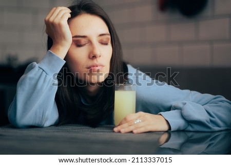 
Tired Woman Having an Effervescent Drink of Calcium and Magnesium. Exhausted person having a migraine feeling stressed and depressed
