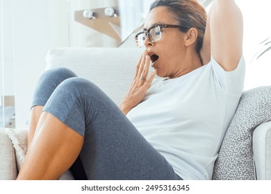 Tired woman at home siting on white chair yawn exhausted wearing sport workout clothes. Vitality and healthy lifestyle female people ready to sleep nap indoor in daylight. Copy space portrait lazy - Powered by Shutterstock