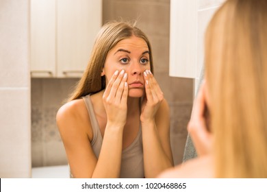 Tired Woman Looking Her Eye Bags In The Bathroom.