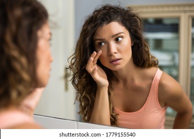 Tired Woman Looking Her Eye Bags In The Bathroom.