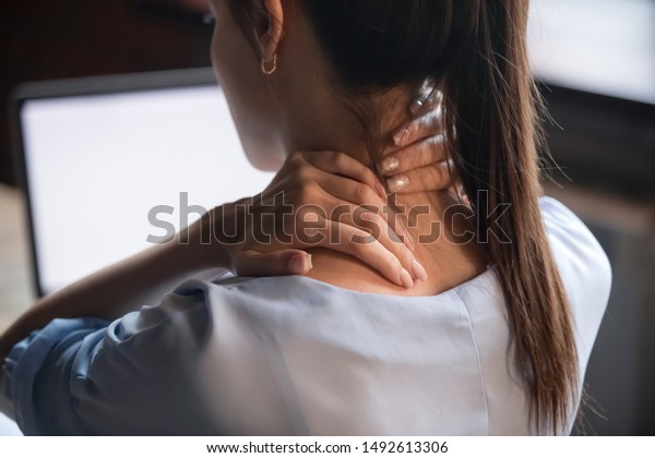 誤った姿勢でのコンピューター作業で疲れた首筋をこすり 痛みを伴う筋肉をマッサージする疲れた女性 関節の腰痛 線維筋痛のコンセプト 後視の接写 の写真素材 今すぐ編集