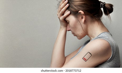 A Tired Woman And A Picture Of A Dead Battery On Her. A Symbol Of Lack Of Energy And Fatigue In A Person