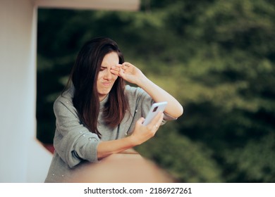 
Tired Woman Rubbing Her Eyes Checking Her Phone. Person Overusing Technology Having A Digital Eye Strain Problem
