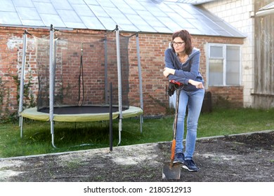 Tired woman taking a break while working in the land of a vegetable garden - Powered by Shutterstock