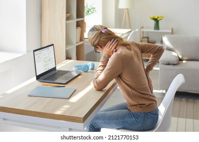 Tired Woman Who Works On Computer At Desk In Sedentary Posture For A Long Time Is Feeling Intense Back Pain. Unhappy Stressed Young Lady Suffering From Radiculitis, Spasm Or Pinched Nerve Inflammation