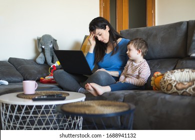 Tired Woman Working On Laptop At Home With Her Child. Single Mother Telecommuting. Telework And Family Concept.