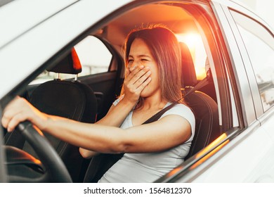 Tired Woman Yawning While Driving Her Car