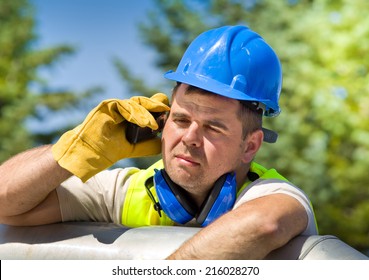 Tired Worker With Walkie Talkie And Safety Equipment On Oil Plant 