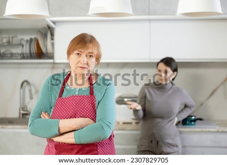 Tired of working in kitchen,sorry mother in apron listens to her daughter s indignant conversation about unsatisfactory life achievements