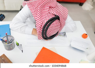 Tired Young Arab Boy Working On Laptop On Desk