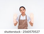 A tired young and asian housekeeper surrenders out of exasperation, putting her hands up. Unable to face difficulty at work. Isolated on a white background.