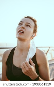 Tired Young Athletic Woman Jogger Taking Off Medical Protective Mask And Free Breathing Deep, Taking Rest After Workout Hard Outdoors. Vertical. Sport During Quarantine,coronavirus, Covid-19 Concept