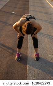 Tired Young Brunette Athletic Woman Runner Taking Rest, Doing Break, Breathing Deep After Hard Outdoor Workout In The Morning. Weight Loss Cardio Goal Achievement Challenge Concept. Vertical