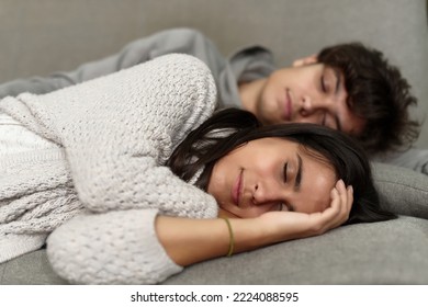 Tired young couple sleeping, taking a nap on her sofa, dreaming carefree, taking a break from work - Shutterstock ID 2224088595