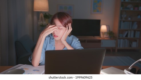 Tired Young Freelance Worker Rubbing Her Eyes While Sitting In Front Of Laptop Computer And Working On Promising Project - Asian Girl Soho Lady Stay Up Late In Home Office Eye Painful