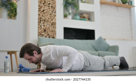 Tired Young Man Doing Pushups On Excercise Mat At Home