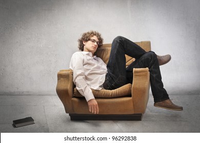 Tired Young Man Lying On An Armchair