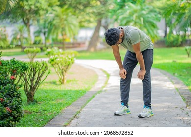 Tired young man runner taking a rest after running hard at the park - Powered by Shutterstock