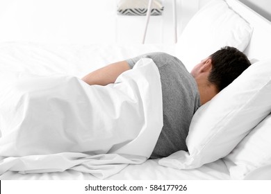 Tired Young Man Sleeping In Bed