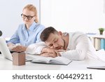 Tired young man sleeping during conference in office