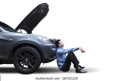 Tired young man waiting a help while sitting near the broken car, isolated on white - Powered by Shutterstock