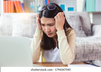 Tired young university student asian  woman with stressed and headache with learn online lesson. Young female can not understand when teacher teaching on online internet by study at home She get bored