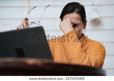 Tired young woman feel pain eyestrain holding glasses rubbing dry irritated eyes fatigued from computer work. High quality photo