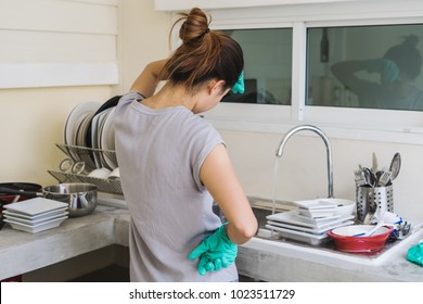 Tired Young Woman With Gloves Washing Dishes In The Kitchen, House Work Concept