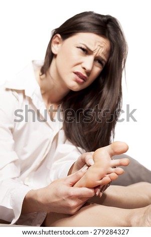 tired young woman massaging her feet