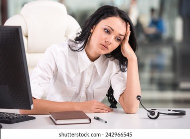 Tired Young Woman Is Sitting At The Table At Work In A Call Center.