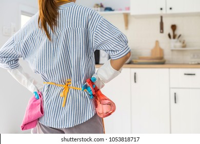 Tired Young Woman Standing At Kitchen Room With Cleaning Products And Equipment, Housework Concept