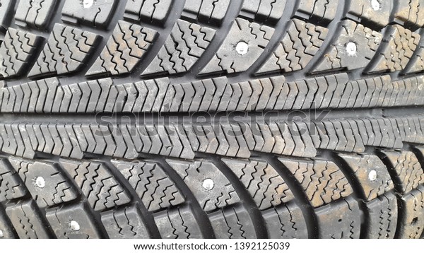 Tires. Car tires. Rubber. Studded\
tires. Old car tires. Tread. Car wheel protector close\
up