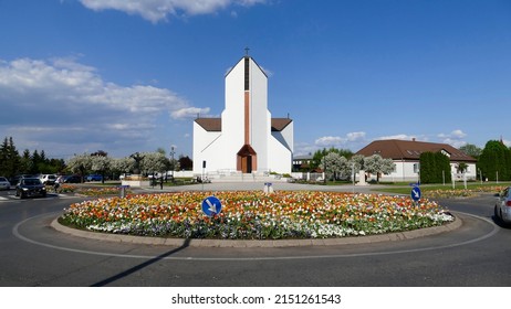 Tiszaujvaros, Hungary - April 29. 2022: Modern Catholic Church With Hundreds Of Tulips In The Roundabout In Eastern Hungary