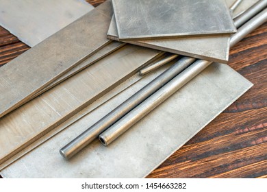 Titanium Alloys Plates Bars Pins Stock Hole Tubing Thong Sheet For Knife Handle Knife Making Materials Supply On The Brown Wooden Background