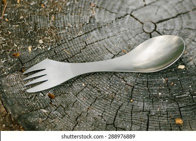 titanium spork lying on a wooden stump in the forest