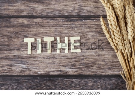 Tithe text with ripe wheat on wooden background. Top view. Generosity, Christian giving, offering, and faith in God Jesus Christ, biblical concept.