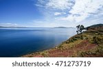 Titicaca or Titiqaqa is a large, deep lake in the Andes on the border of Peru and Bolivia. It is often called the highest navigable lake in the world.