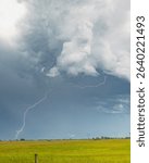 Title: Electric A dramatic bolt of lightning cuts through a turbulent summer sky over the Oklahoma plains, highlighting the raw power of nature. Towering storm clou