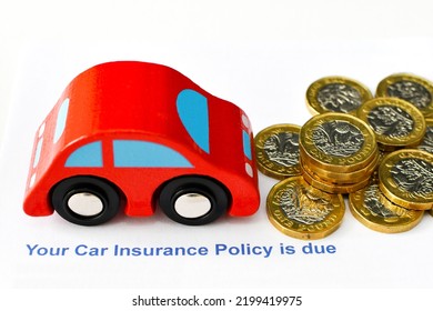 Title Of Insurance Letter For Renewal Of Car Insurance With Toy Car And One Pound Coins On A Plain White Background. Cost Of Living Concept. No People.