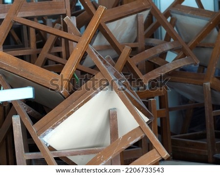Title: Recycling dump with trash of broken chairs, wooden chairs. pile of chairs.