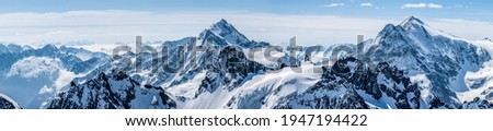 Titlis mountain. Beautiful panorama of snowy alps in white-blue tones.