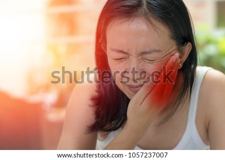 TMD and TMJ concept: Temporomandibular Joint and Muscle Disorder. Asia woman hand on cheek face as suffering from facial pain, mumps  or toothache