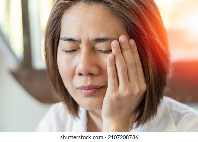 TMD and TMJ healthcare concept: Temporomandibular Joint and Muscle Disorder. Asia man hand on cheek face as suffering from facial pain, mumps or toothache - Shutterstock ID 2107208786