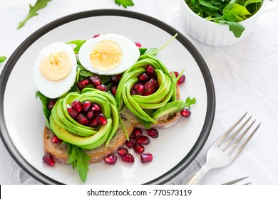 Toast With Avocado Rose, Boiled Egg And Fresh Salad On White Table Cloth