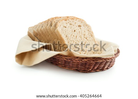 Toast bread in a basket. Wholemeal toast bread slices placed on a cotton cloth napkin in a wicker basket close up isolated on white background.